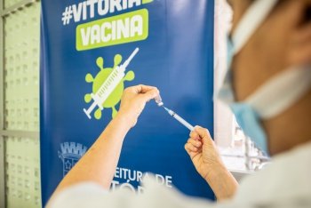 Enfermeiro abastecendo seringa com vacina contra Coronavírus